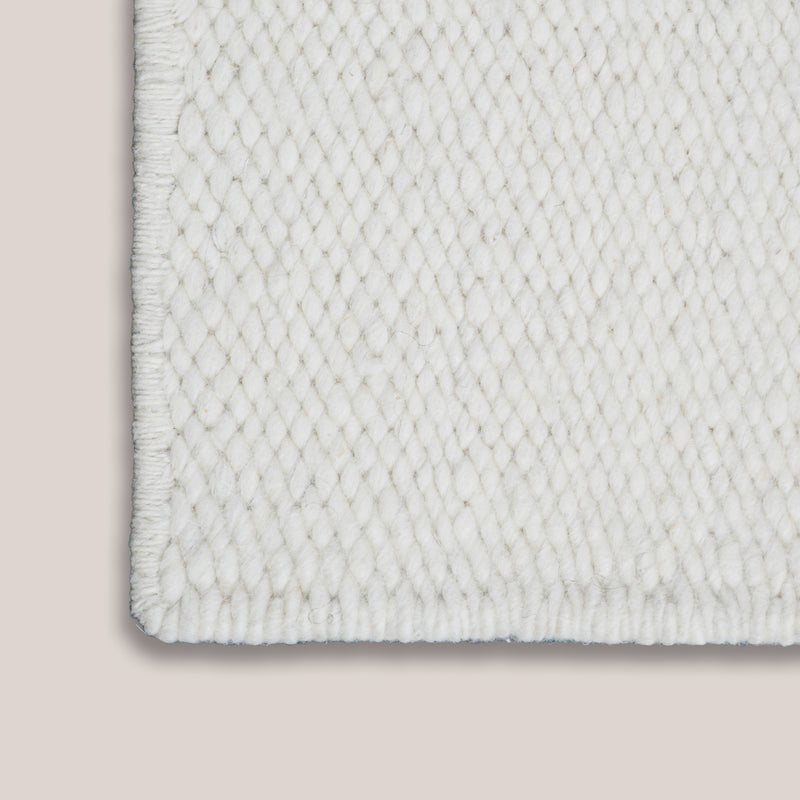 Close-up of the edge of a Handwoven Karakul wool rug, showcasing its texture and quality craftsmanship.