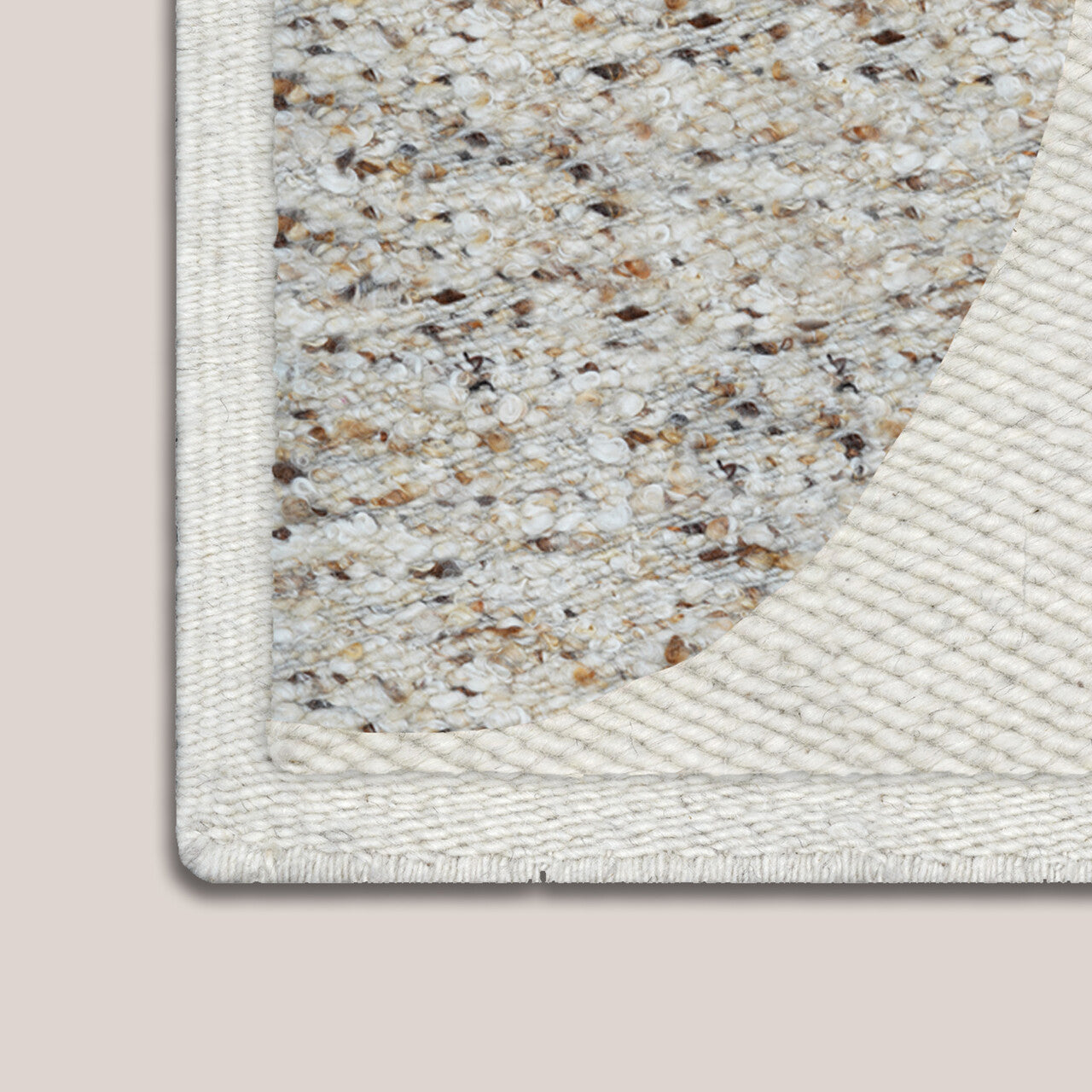 Close-up of a textured rug corner on a beige background