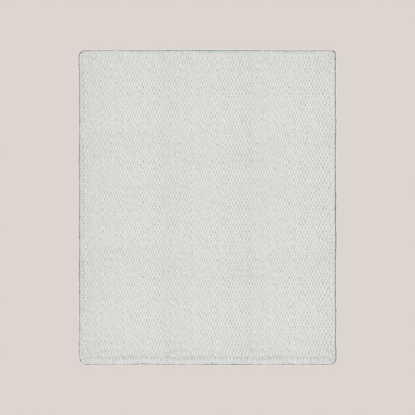 Handwoven Karakul wool rug in a minimalist design featuring a soft light color and textured surface.